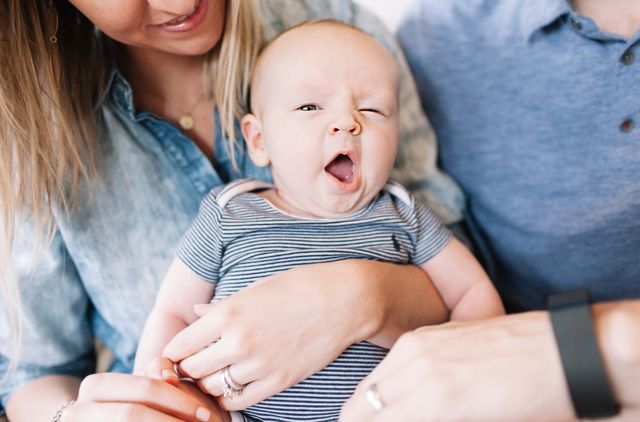 Baby yawning in his parents arms after being born using their GMHBA cover
