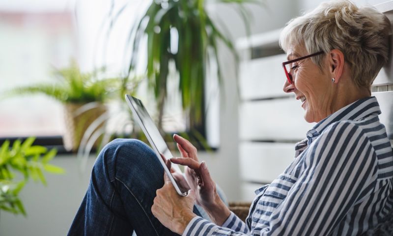 Mature woman using her ipad for a telehealth appointment that she can claim with GMHBA extras