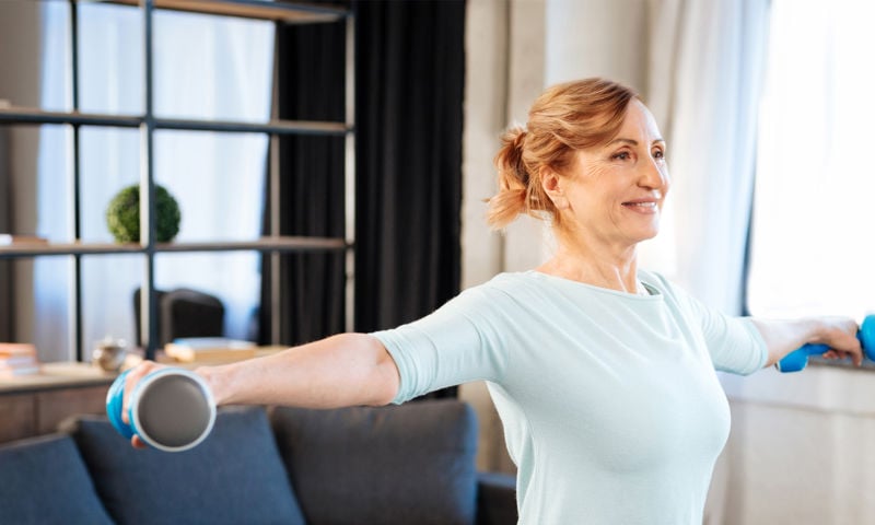 Old lady stretching with weights