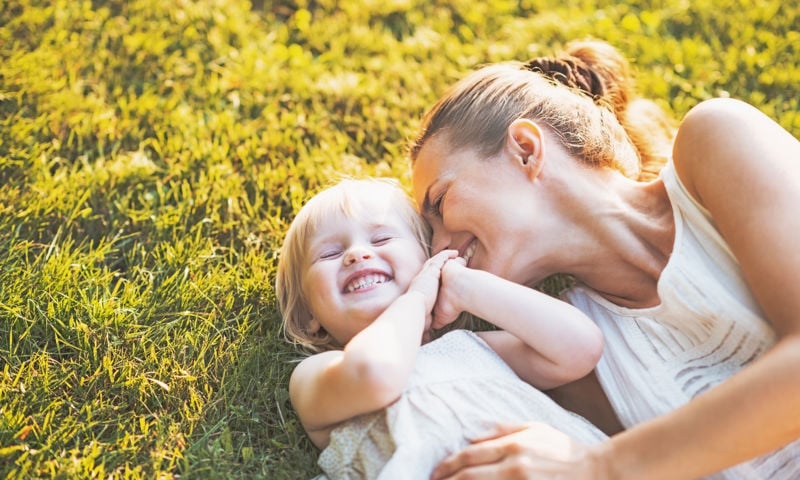 Woman playing with her kid on the grass