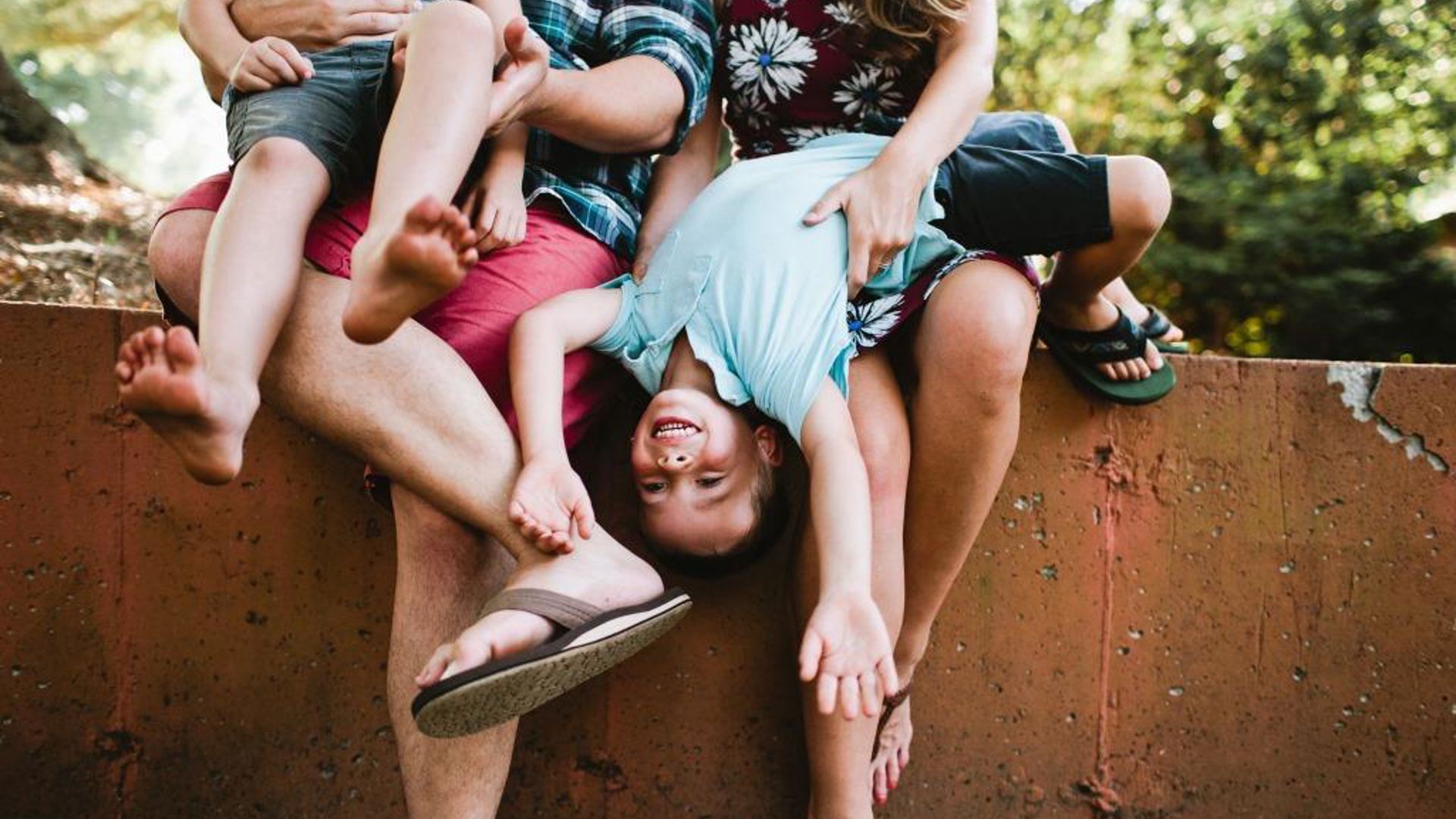 Parents dangling and tickling kid