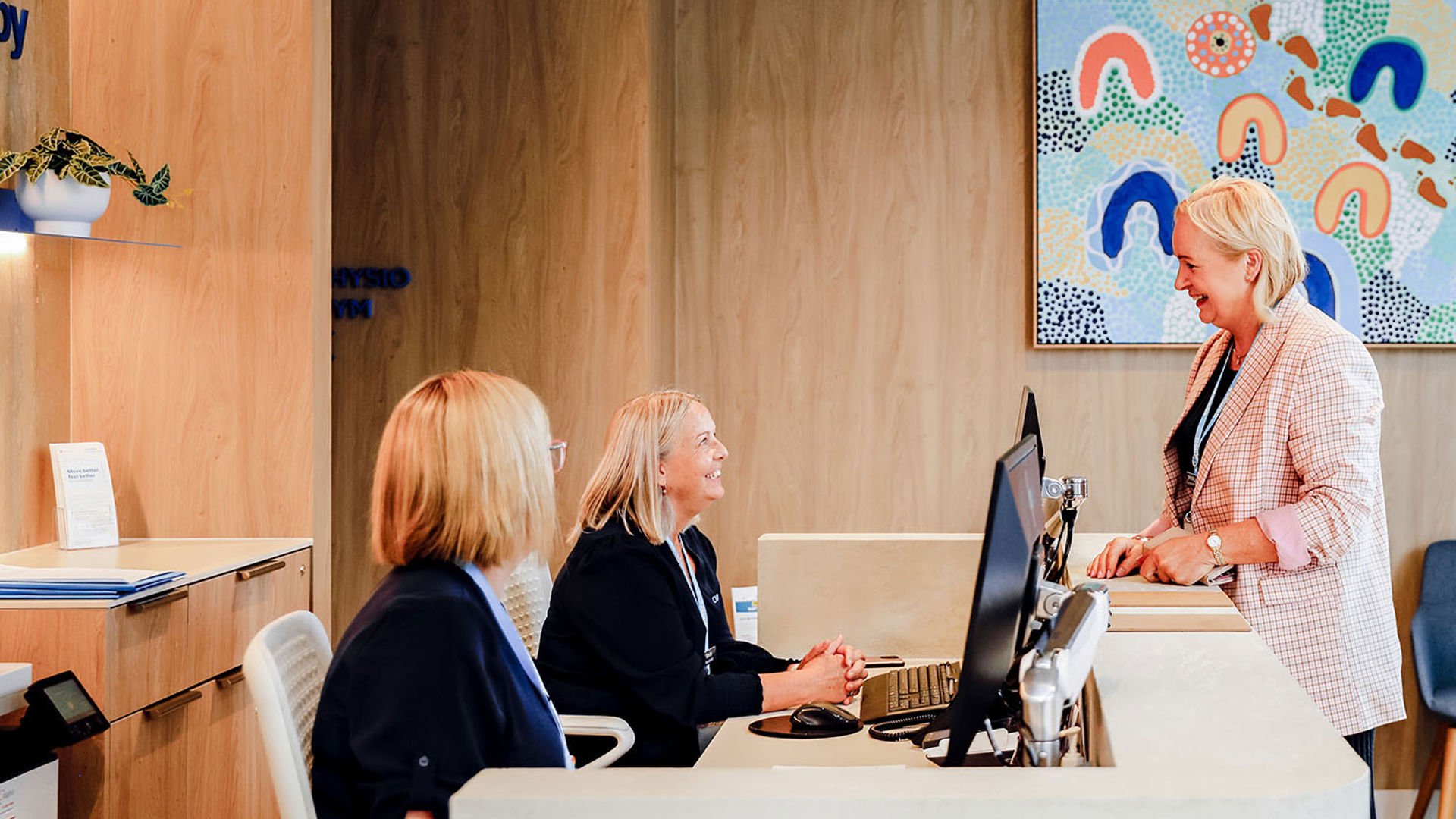 Friendly GMHBA medical team greeting patient at reception