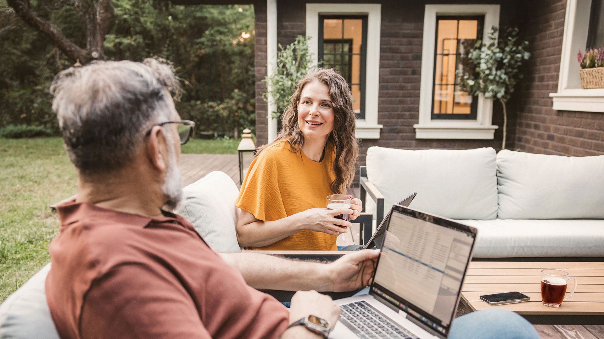 middle aged couple enjoying a coffee on their deck chatting about health insurance