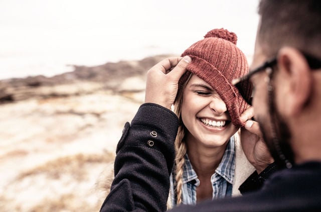 Laughing GMHBA Extras member and partner playing with her beanie 