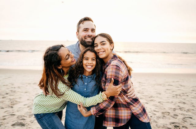 Happy family enjoying a summer night on the beach