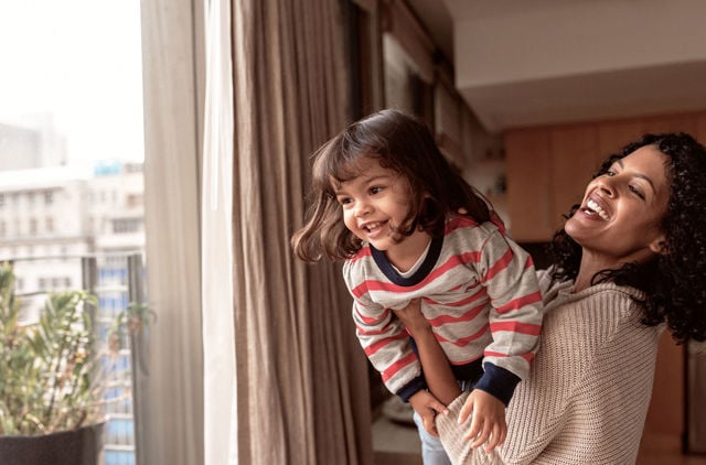 Mother and daughter playing near window