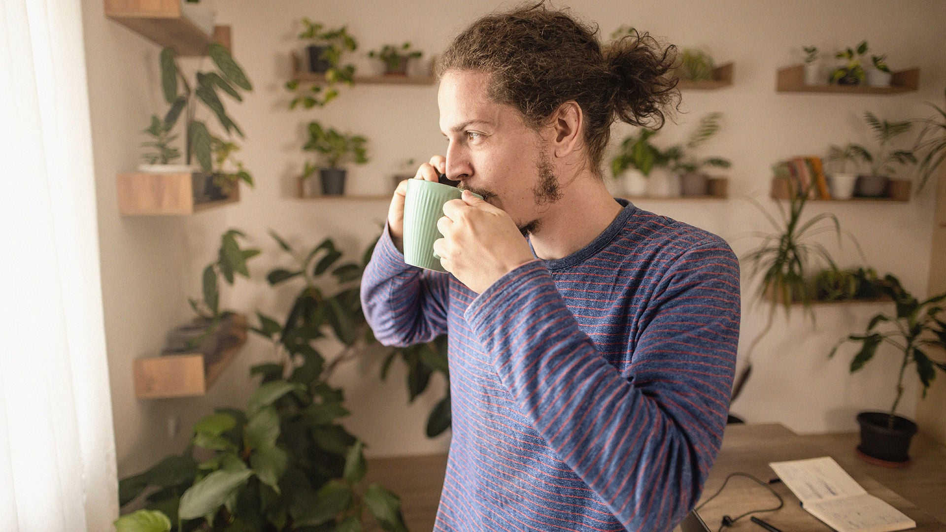 Man drinking his morning coffee on the phone to GMHBA health insurance