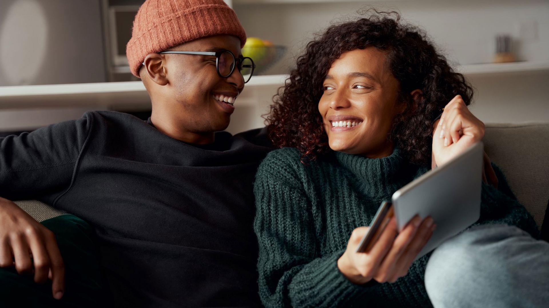 Young couple relaxing on the couch and using a tablet computer
